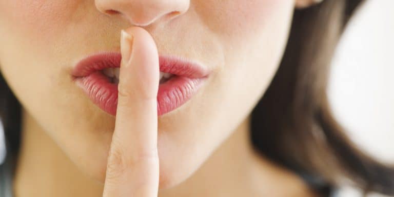 Young woman with finger on lips, close-up