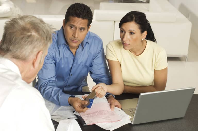 husband and wife speaking with financial advisor to talk about buying tradelines