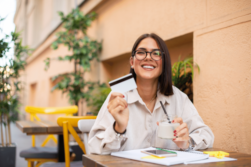 Happy woman holding a credit card. How to buy authorized user tradelines.