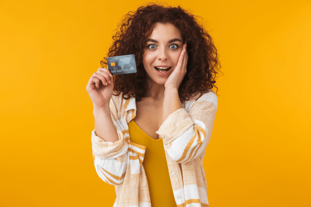 Happy woman holding a credit card. The Ultimate Guide to Purchasing Tradelines.