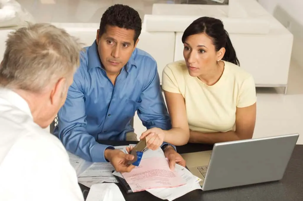 husband and wife speaking with financial advisor to talk about buying tradelines